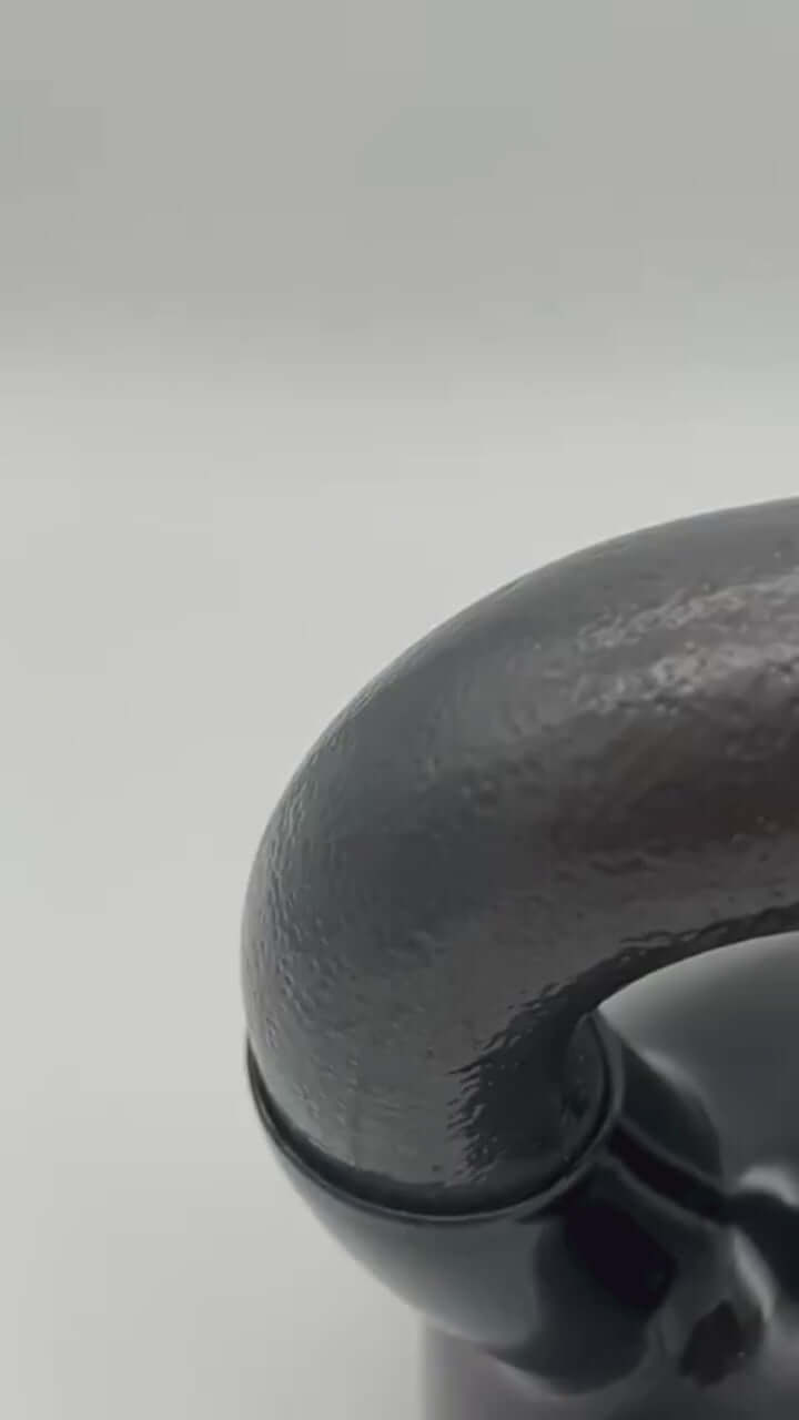 Close-up of the ergonomic handle of a 16 KG vinyl kettlebell for comfortable grip during workouts.